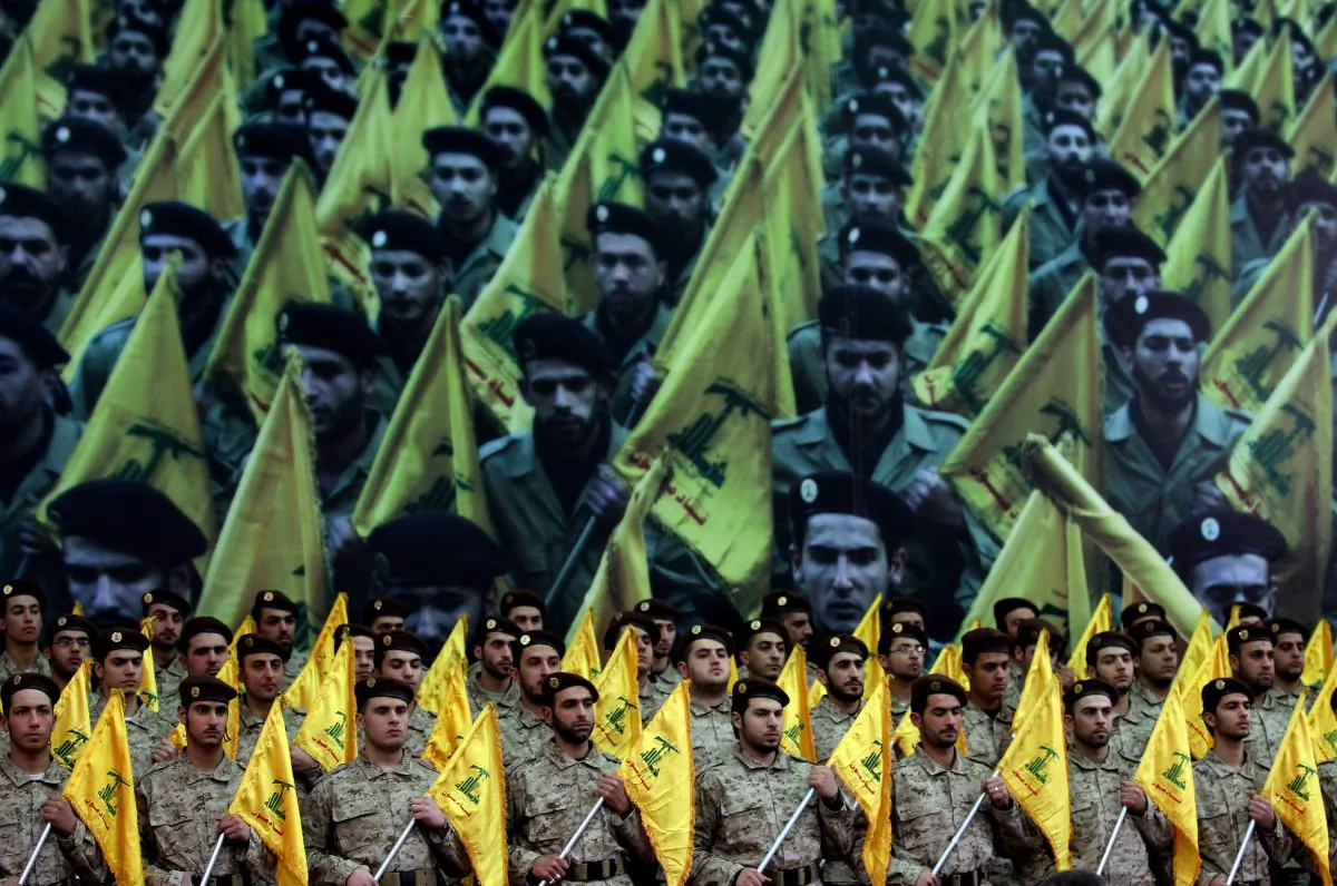 Shiite Muslims Hezbollah militants stand to attention as hundreds of people gather in a huge hall waiting to watch a televised speech by Hassan Nasrallah, the leader of the Shiite Muslim Lebanese Hezbollah militant group on February 22, 2008, in Beirut's southern suburb, ten days after the assassination of Hezbollah commander Imad Mughnieh in a bomb attack in Damascus. Nasrallah's televised speech marked the killing of Mughnieh and the 1992 assassination of its former leader Abbas Mussawi in an Israeli helicopter strike and assassinated Sheikh Ragheb Harb in 1984.  AFP PHOTO / JOSEPH BARRAK (Photo credit should read JOSEPH BARRAK/AFP/Getty Images)