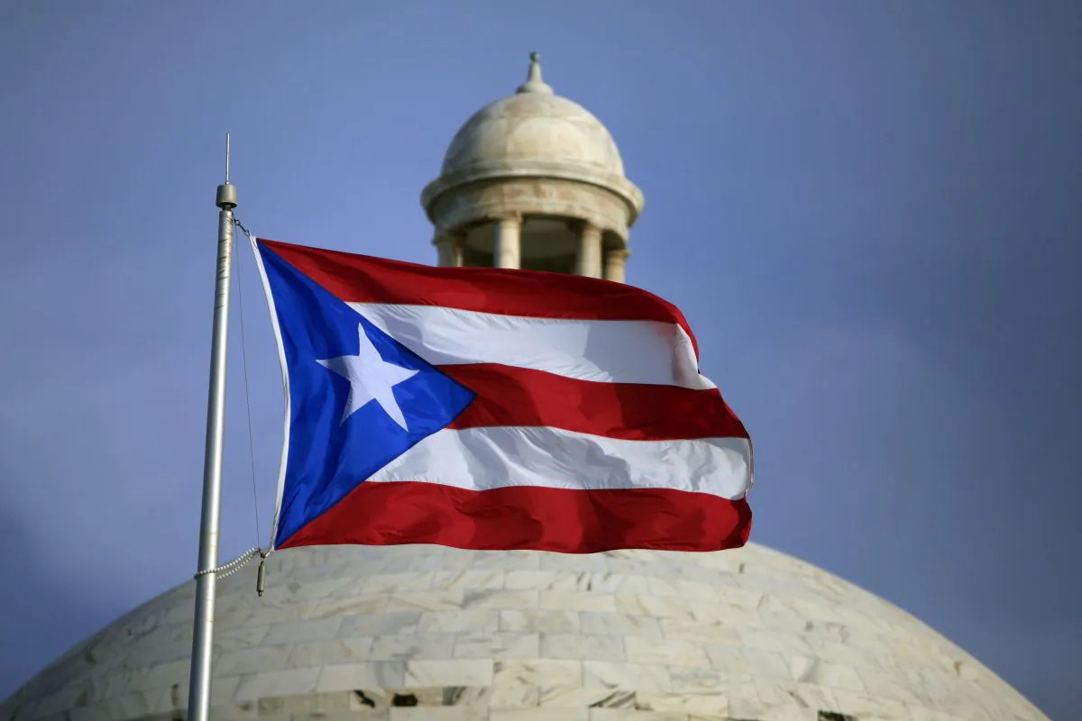The Puerto Rican flag flies in front of Puerto Rico’s Capitol as in San Juan on July 29, 2015.  (AP Photo/Ricardo Arduengo)