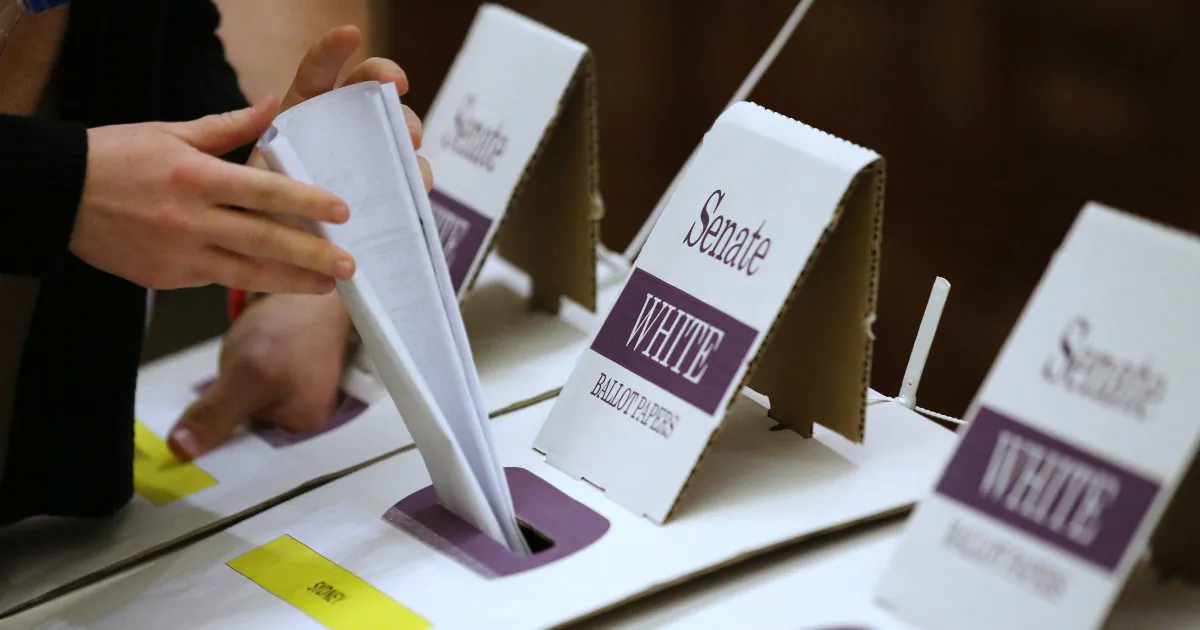 A voter drops their ballot in a box at a polling station at Town Hall in Sydney on July 2, 2016. (Rick Rycroft/AP Photo)