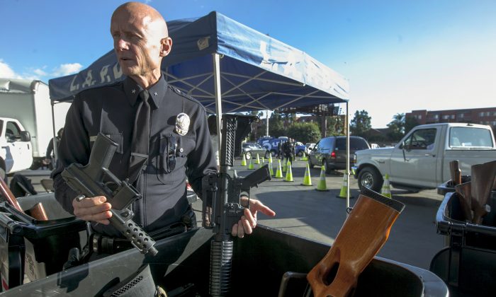 Then Los Angeles Police Cmdr. Andrew Smith, Media Relations and Community Affairs Group, shows assault weapons exchanged at the LA Memorial Sports Arena in Los Angeles on Dec. 26, 2012. (Damian Dovarganes/AP Photo)