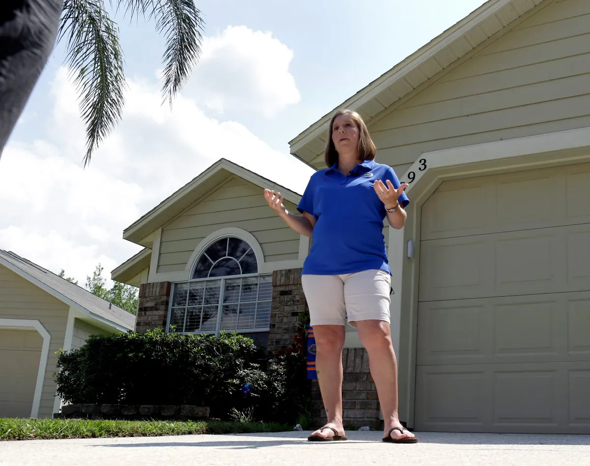 Homeowner Michelle Harner stands in front of her house in the Piedmont Park neighborhood in Apopka, Fla., on April 14, 2016. (AP Photo/John Raoux)