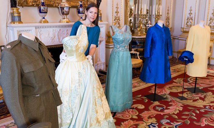 LONDON, ENGLAND - JULY 04:  A conservator attends to outfits from the Queen's wardrobe during the press preview of 'Fashioning A Reign: 90 years Of Style From The Queen's Wardrobe' at Buckingham Palace on July 4, 2016 in London, England.  (Photo by Ian Gavan/Getty Images)