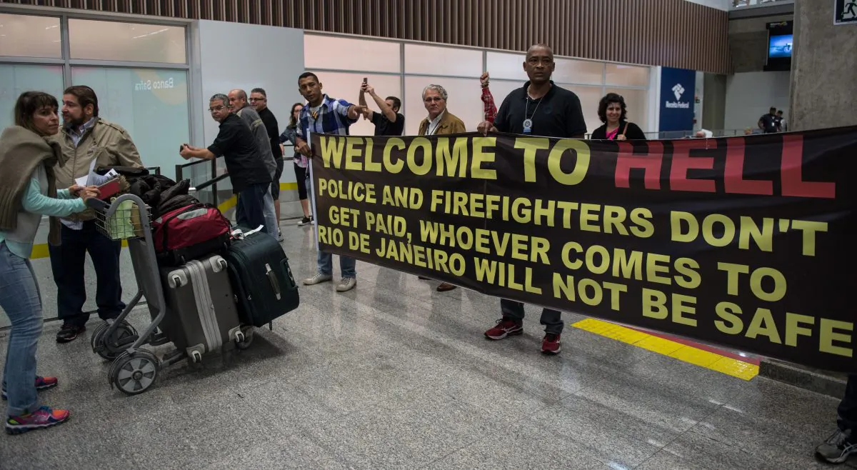 Police officers and firemen welcome passengers with a protest banner at the Tom Jobim International Airport in Rio de Janeiro on July 4. (Vanderlei Almeida/AFP/Getty Images)