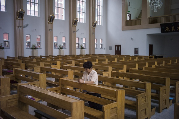 A woman prays at a Catholic church in Tianjin on June 7, 2015. Many churches in China’s province of Zhejiang have been turned into cultural centers. (Fred Dufour/AFP/Getty Images)