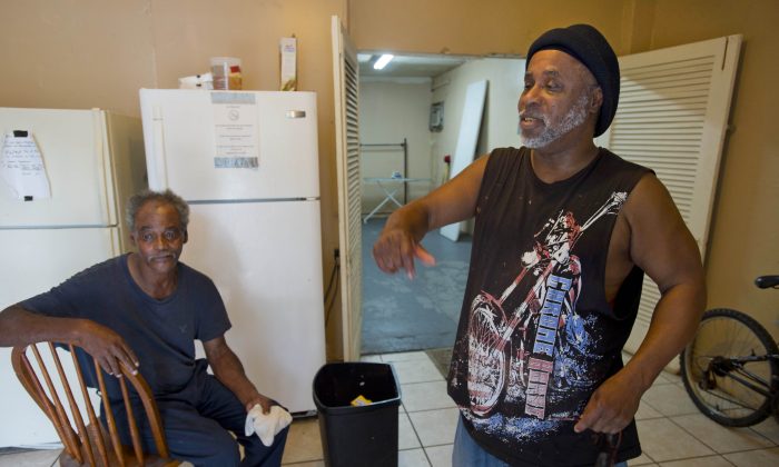 David Solomon, 60, left, and Calvin Wilson, 56, right, say they lived with Alton Sterling at the Living Waters Outreach Ministry Drop-In Center, and don't believe he carried a gun, on Tuesday, July 5, 2016, in Baton Rouge. Sterling was fatally shot during an altercation with Baton Rouge Police in the early morning hours of Tuesday, outside a Baton Rouge convenience store. (Travis Spradling/The Advocate via AP)