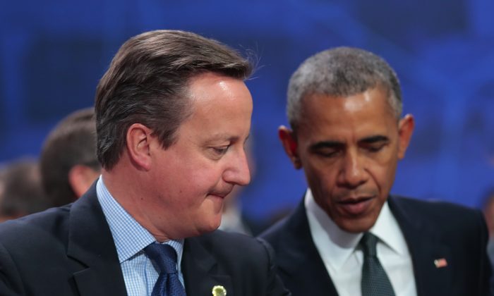 British Prime Minister David Cameron grimaces sitting next to US President Barack Obama before the first working session of the North Atlantic Council at the NATO summit in Warsaw, Poland, Friday, July 8, 2016. Starting Friday, US President Barack Obama and leaders of the 27 other NATO countries will take decisions in Warsaw on how to deal with a resurgent Russia, violent extremist organizations like Islamic State, attacks in cyberspace and other menaces to allies' security during a summit described by many observers as NATO's most crucial meeting since the 1989 fall of the Berlin Wall.(AP Photo/Markus Schreiber)