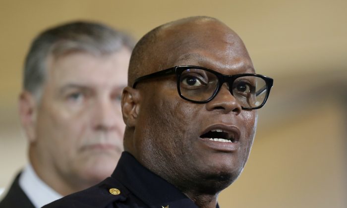 Dallas police chief David Brown, front, and Dallas mayor Mike Rawlings, rear, talk with the media during a news conference, Friday, July 8, 2016, in Dallas.  Snipers opened fire on police officers in the heart of Dallas Thursday night, during protests over two recent fatal police shootings of black men. (AP Photo/Eric Gay)