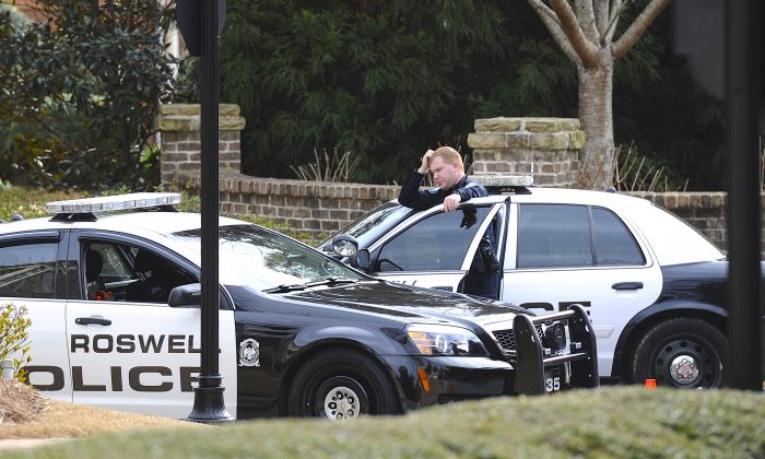 Roswell Police officers stand guard in this file photo taken on Jan. 31, 2015, in Roswell, Ga. Roswell police said on July 8, 2016, that one of their officers had been shot at. (AP Photo/John Amis)
