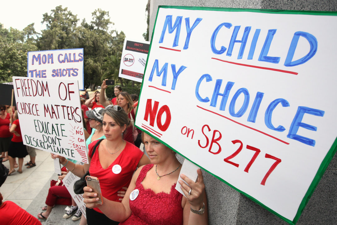 Karman Willmer, left, and Shelby Messenger protest against SB277, a measure requiring California schoolchildren to get vaccinated, at a Capitol rally, Tuesday, June 9, 2015, in Sacramento, Calif. (AP Photo/Rich Pedroncelli)