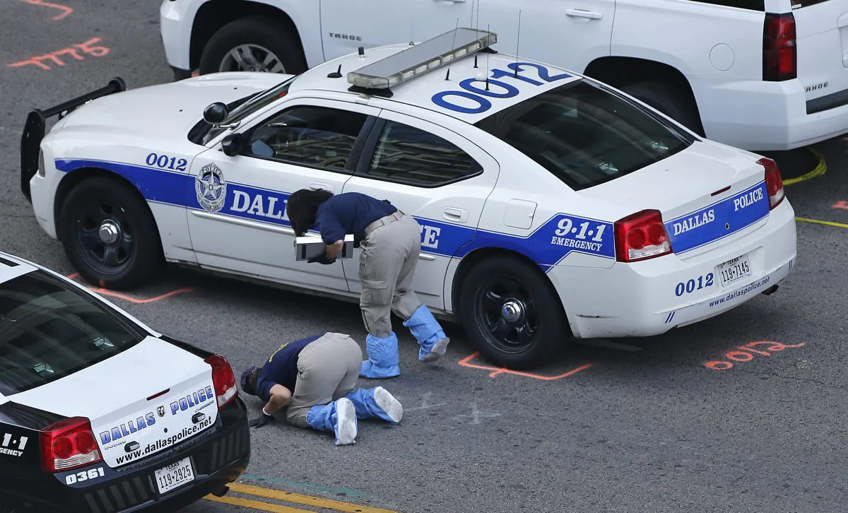 An FBI evidence response team works the crime scene, Sunday, July 10, 2016, where five Dallas police officers were killed Thursday, in Dallas. A peaceful protest over the recent videotaped shootings of black men by police turned violent Thursday night as gunman Micah Johnson shot at officers, killing five and injuring seven, as well as two civilians. (AP Photo/Gerald Herbert)