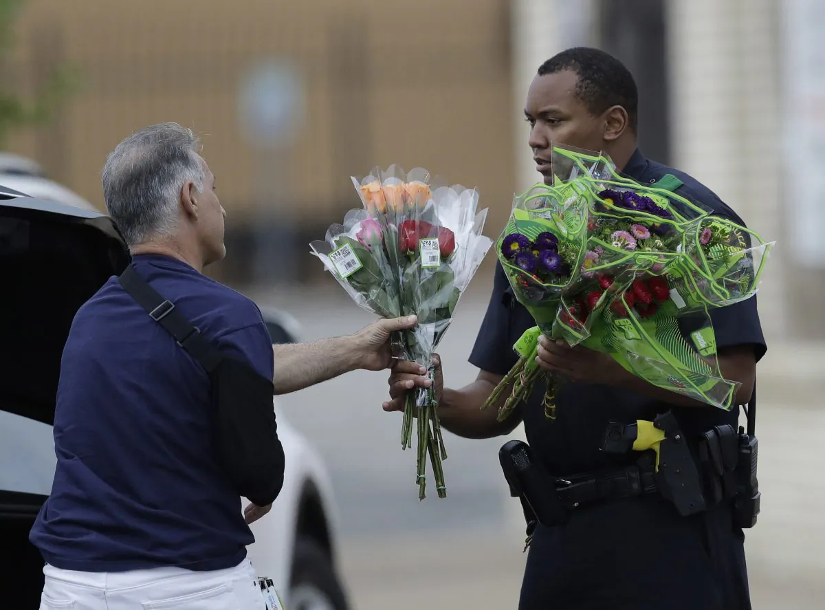 A Dallas police officer receivers flowers at a roadblock outside their headquarters in Dallas on July 9, 2016. (AP Photo/Eric Gay)