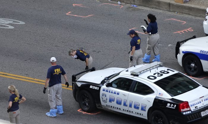 An FBI evidence response team works the crime scene, Sunday, July 10, 2016, where five Dallas police officers were killed Thursday, in Dallas. A peaceful protest over the recent videotaped shootings of black men by police turned violent Thursday night as gunman Micah Johnson shot at officers, killing five and injuring seven, as well as two civilians. (AP Photo/Gerald Herbert)