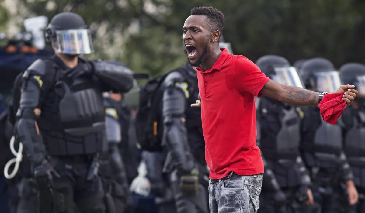 A protester yells at police in front of the Baton Rouge Police Department headquarters after police arrived in riot gear to clear protesters from the street in Baton Rouge, La., on July 9, 2016. Several protesters were arrested. (AP Photo/Max Becherer)