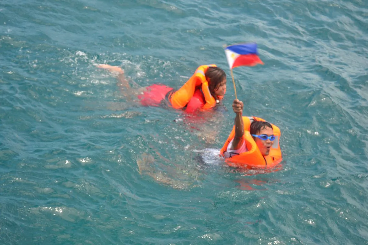 Swimmers Mariel Ipan and Andresito Villato heading to plant the flag on Scarborough Shoal, on June 13, 2016, in the West Philippine Sea.. (Kalayann Atin Ito)