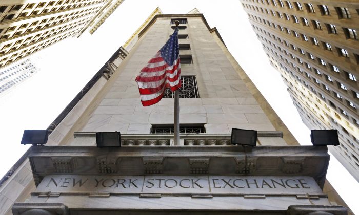 FILE - In this Friday, Nov. 13, 2015, file photo, the American flag flies above the Wall Street entrance to the New York Stock Exchange. Stocks are opening solidly higher on Wall Street, Tuesday, July 12, 2016, putting the market on track for another milestone. The Dow Jones industrial average was trading above its previous record high close in early trading. That came a day after the Standard & Poor's 500 index closed at its own record high. (AP Photo/Richard Drew, File)