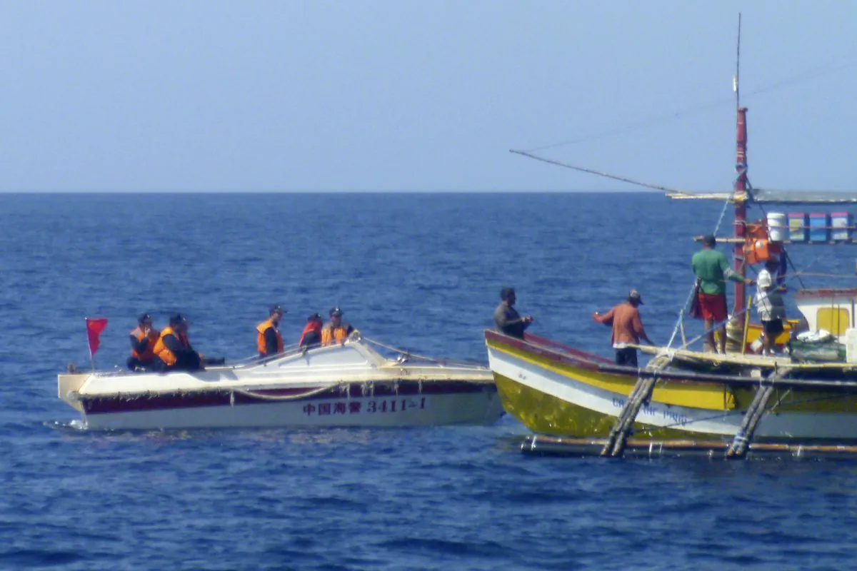 In this Feb. 27, 2015, photo, provided by Filipino fisherman Renato Etac, Chinese Coast Guard members approach Filipino fishermen near Scarborough Shoal in the South China Sea. An international tribunal has found that there is no legal basis for China's claiming rights to much of the South China Sea. The Permanent Court of Arbitration (PCA) issued its ruling Tuesday, July 12, 2016, in The Hague in response to an arbitration case brought by the Philippines against China regarding the South China Sea, saying that any historic rights to resources that China may have had were wiped out if they are incompatible with exclusive economic zones established under a U.N. treaty. (Renato Etac via AP)