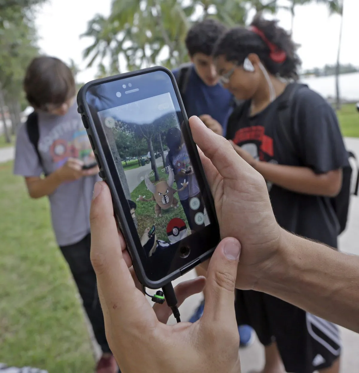 FILE - In this Tuesday, July 12, 2016, file photo, Pinsir, a Pokemon, is found by a group of Pokemon Go players at Bayfront Park in downtown Miami. The "Pokemon Go" craze has sent legions of players hiking around cities and battling with "pocket monsters" on their smartphones. (AP Photo/Alan Diaz, File)