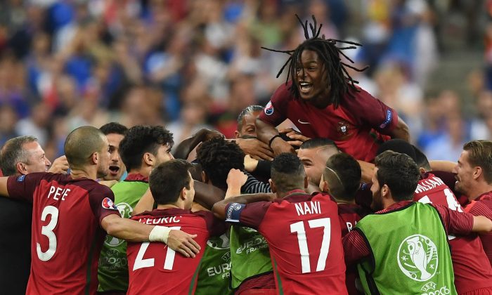 Renato Sanches (top) and Portugal players celebrate their team's first goal scored by Eder (obscured) during the UEFA EURO 2016 Final match between Portugal and France at Stade de France on July 10 in Paris, France. (Laurence Griffiths/Getty Images) 