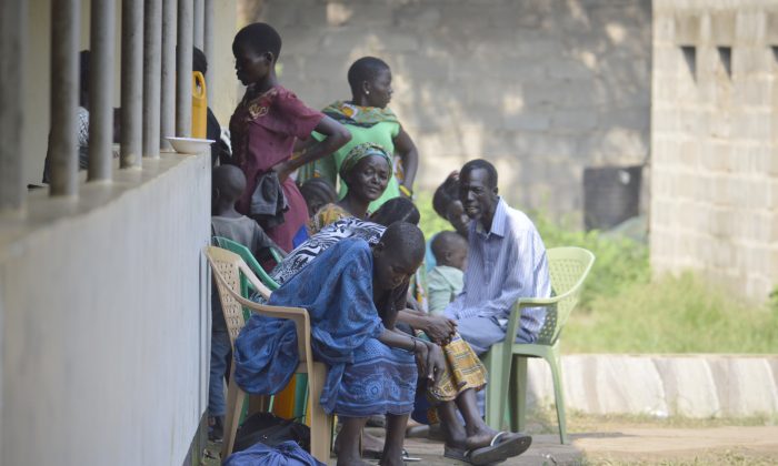 In this Tuesday July 12, 2016 photo, people take shelter near the All Saints Church in Juba, South Sudan. Embassies and aid organizations in South Sudan were trying to evacuate staff from the capital, Juba, on Tuesday as a precarious calm settled over the city following several days of deadly clashes. (AP Photo)