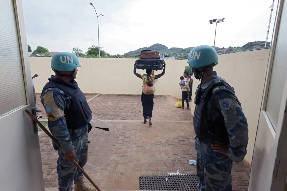 In this photo taken Wednesday, July 13, 2016 and released by the United Nations Mission in South Sudan (UNMISS), villagers are led by UN soldiers to the UN compound in the capital Juba, South Sudan. The death toll from a recent outbreak of fighting in South Sudan is almost certain to climb above the 272 people, including 33 civilians, reported by the government, United Nations officials said Wednesday (Eric Kanalstein/UNMISS via AP)