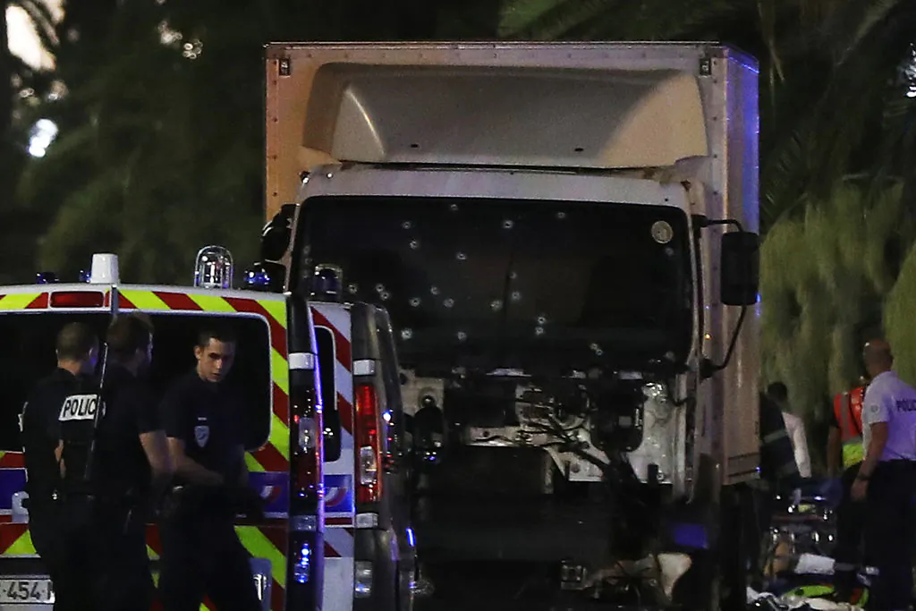 Police officers stand near a van, with its windscreen riddled with bullets, that ploughed into a crowd leaving a fireworks display in the French Riviera town of Nice on July 14, 2016.
Up to 30 people are feared dead and over 100 others were injured after a van drove into a crowd watching Bastille Day fireworks in the French resort of Nice on July 14, a local official told French television, describing it as a "major criminal attack". / AFP / VALERY HACHE        (Photo credit should read VALERY HACHE/AFP/Getty Images)