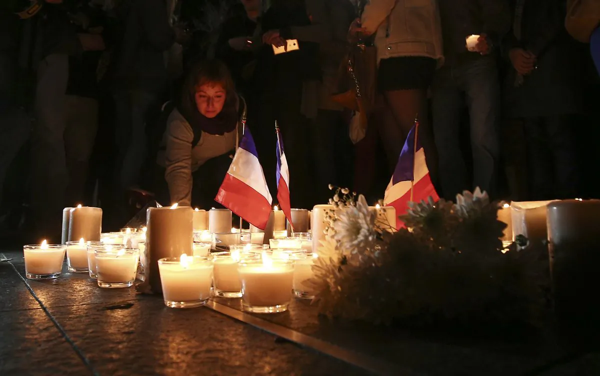 A woman places a candle during a vigil to honor victims of the Bastille Day tragedy in Nice, France, in Sydney, Australia, on July 15, 2016. (AP Photo/Rob Griffith)