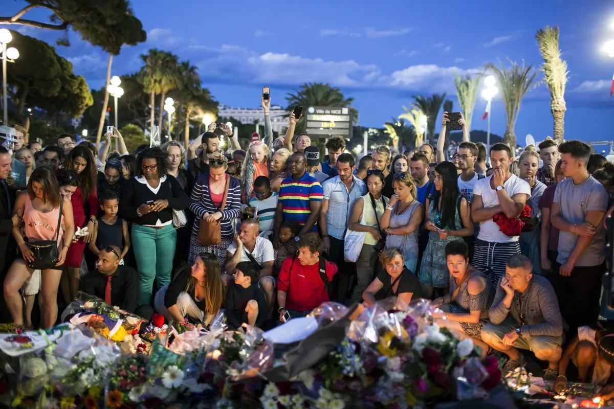 People gather at a makeshift memorial to honor the victims of an attack, near the area where a truck mowed through revelers in Nice, southern France, on July 15, 2016. (AP Photo/Laurent Cipriani)