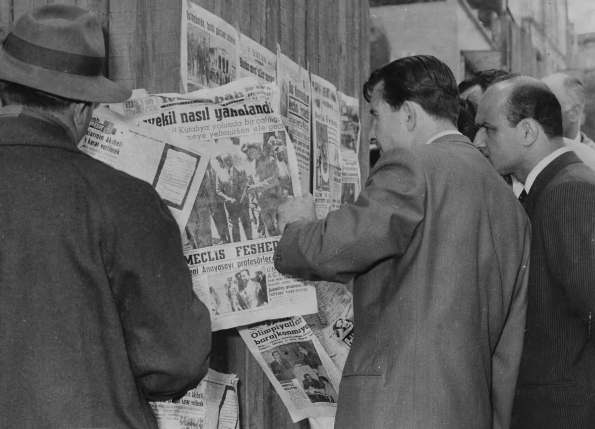 Citizens stand at a newsstand read of the capture of Prime Minister Adnan Menderes after a military coup in Istanbul, Turkey, on May 28, 1960. (AP Photo)
