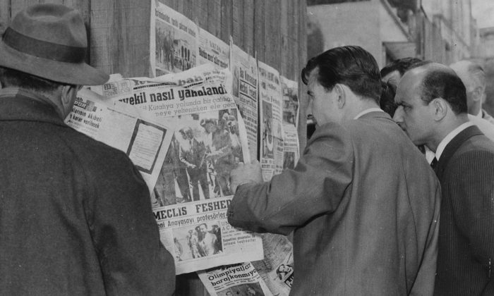 Citizens stand at a newsstand read of the capture of Prime Minister Adnan Menderes after a military coup in Istanbul, Turkey, on May 28, 1960. (AP Photo)