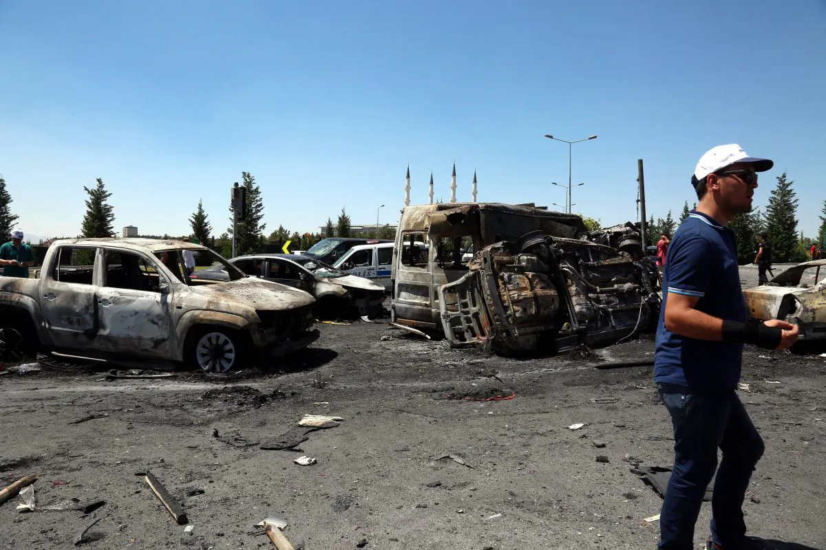 A man walks next to destroyed cars outside the presidential palace in Ankara, Turkey, on July 16, 2016. (AP Photo/Ali Unal)
