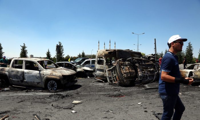 A man walks next to destroyed cars outside the presidential palace in Ankara, Turkey, on July 16, 2016. (AP Photo/Ali Unal)