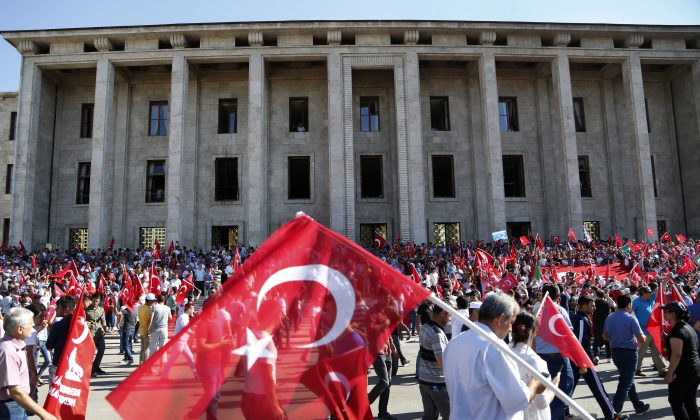 Turkish citizens wave their national flags as they protest against the military coup outside Turkey's parliament near the Turkish military headquarters in Ankara, Turkey, on July 16, 2016. (AP Photo/Hussein Malla)