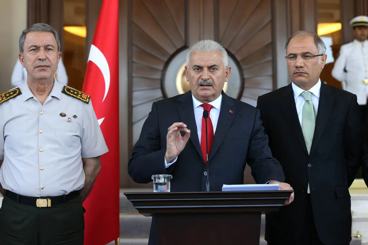 Turkish Prime Minister Binali Yildirim (R), flanked by Chief of the General Staff of the Turkish Armed Forces General Hulusi Akar (L) and Turkish Interior Minister Efkan Ala (R), gives a press conference outside the Cankaya Palace in Ankara, on July 16, 2016. (Adem Altan/AFP/Getty Images)