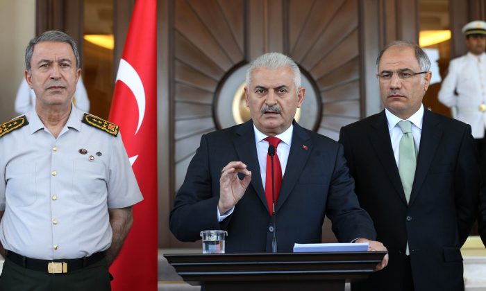 Turkish Prime Minister Binali Yildirim (R), flanked by Chief of the General Staff of the Turkish Armed Forces General Hulusi Akar (L) and Turkish Interior Minister Efkan Ala (R), gives a press conference outside the Cankaya Palace in Ankara, on July 16, 2016. (Adem Altan/AFP/Getty Images)