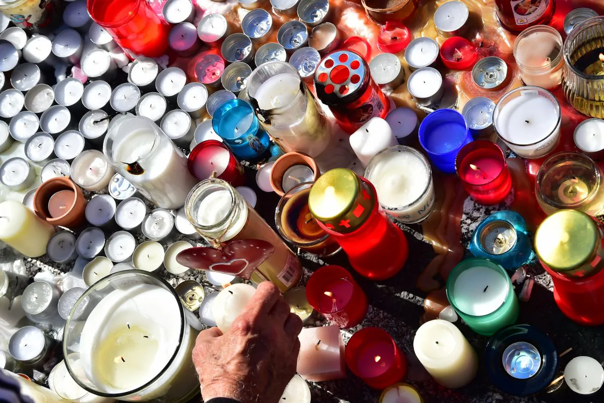 A man lights a candle at a makeshift memorial on the pavement at the Promenade des Anglais in Nice on July 16, 2016 in tribute to the victims of the deadly Bastille Day attack. (Giuseppe Cacace/AFP/Getty Images)