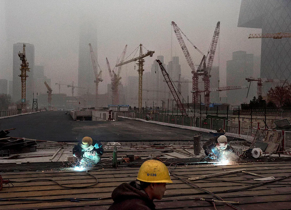 Chinese workers weld at a construction site in heavy pollution on Nov. 29, 2014 in Beijing. (Kevin Frayer/Getty Images)