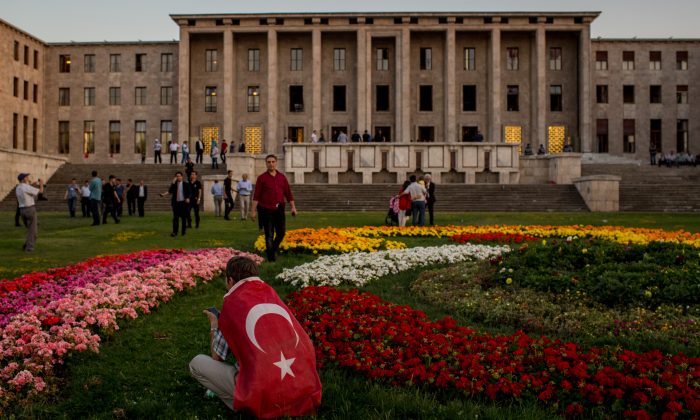 A man sits in front of Parliament House after listening to official speeches during a rally in reaction to the attempted military coup in Ankara, Turkey, on July 16, 2016. (Chris McGrath/Getty Images)