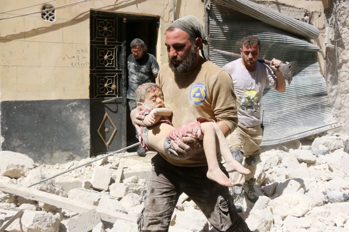 A Syrian civil defence worker carries the body of a child following reported airstrikes on July 17, 2016 in the rebel-controlled neighborhood of Maysar in the northern Syrian city of Aleppo. (Thaer Mohammed/AFP/Getty Images)