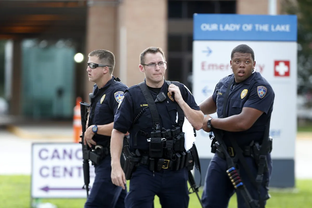 Police guard the emergency room entrance of Our Lady Of The Lake Medical Center, where wounded officers were brought, in Baton Rouge, La., Sunday, July 17, 2016. (AP Photo/Gerald Herbert)