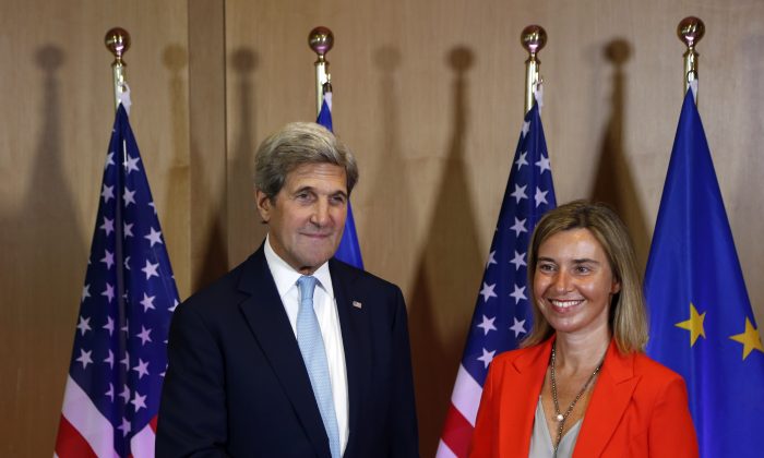European Union High Representative Federica Mogherini, right, shakes hands with U.S. Secretary of State John Kerry at the EU Council building in Brussels, Belgium, Monday, July 18, 2016. (AP Photo/Darko Vojinovic)