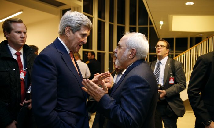FILE - In this Jan. 16, 2016 file-pool photo, Secretary of State John Kerry talks with Iranian Foreign Minister Mohammad Javad Zarif in Vienna, after the International Atomic Energy Agency (IAEA) verified that Iran has met all conditions under the nuclear deal. A document obtained by The Associated Press Monday, July 18, 2016, says key nuclear restrictions on Iran will ease in a little more than a decade, halving the time Tehran would need to build a bomb if it chose to do so. The document says that 11 to 13 years into the 15-year agreement, Iran can replace the 5,060 inefficient centrifuges it now uses to enrich uranium with up to 3,500 advanced machines. (Kevin Lamarque/Pool via AP, File)