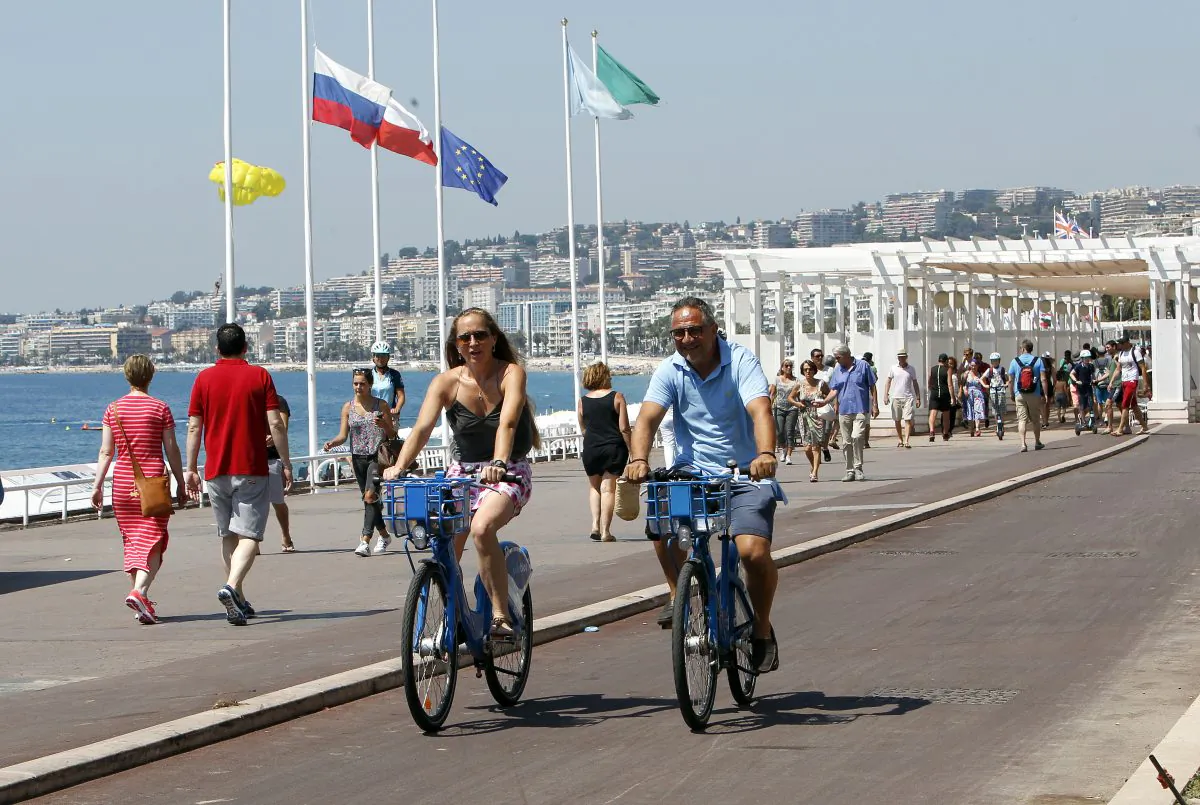 People ride bicycles along the Promenade des Anglais in Nice, southern France, Tuesday, July 19, 2016. (AP Photo/Claude Paris)