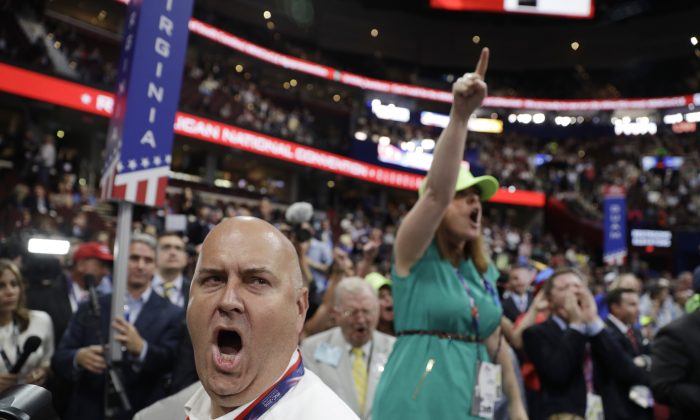 Illinois delegate Christian Gramm, left, and other delegates react as some call for a roll call vote on the adoption of the rules during first day of the Republican National Convention in Cleveland, Monday, July 18, 2016. (AP Photo/John Locher)