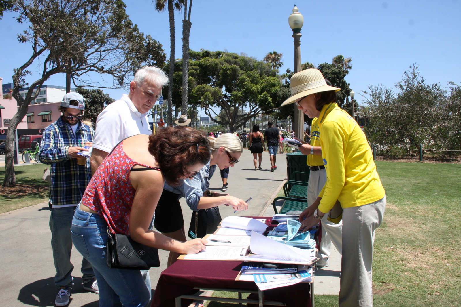 Falun Gong practitioners raise awareness about organ harvesting and other human rights crimes in China, with residents and tourists in Santa Monica, Calif., on July 17. (Xu Touhui/Epoch Times)