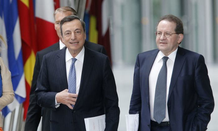 President of the European Central Bank Mario Draghi, left, is on his way to a press conference in Frankfurt, Germany, Thursday, July 21, 2016, after a meeting of the governing council.  At right vice president Vitor Constancio. (AP Photo/Michael Probst)