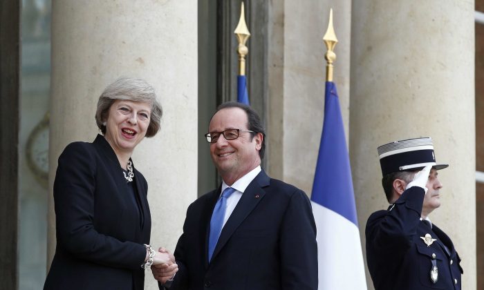 France's President Francois Hollande, centre, greets Britain's Prime Minister Theresa May prior to a meeting at the Elysee Palace, in Paris, Thursday, July 21, 2016. (AP Photo/Thibault Camus)