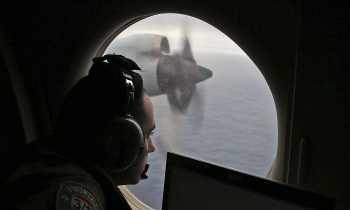 In this March 22, 2014 file photo, flight officer Rayan Gharazeddine on board a Royal Australian Air Force AP-3C Orion, searches for the missing Malaysia Airlines Flight MH370 in southern Indian Ocean, Australia. (AP Photo/Rob Griffith, File)