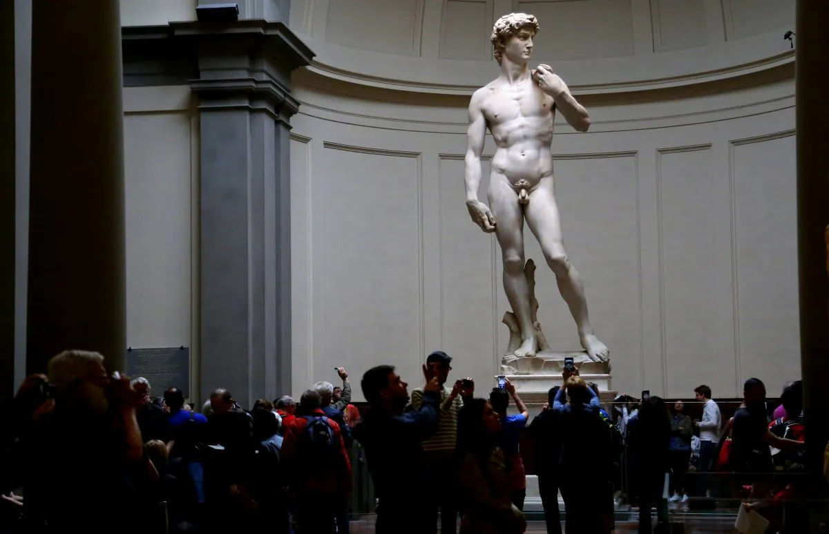 Visitors to the Accademia Gallery in Florence, Italy, pause to admire and take photos of Michelangelo's marble Renaissance masterpiece "David" on April 22, 2016. (Michelle Locke via AP)