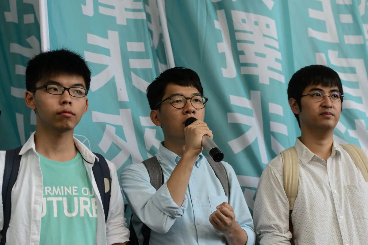 Pro-democracy political activists and members of the Demosisto party (L to R) Joshua Wong, Nathan Law and Alex Chow, speak as they arrive at the Eastern Court in Hong Kong on July 21, 2016.
The three were to face a court verdict over charges related to a protest leading up to pro-democracy rallies in 2014. (ANTHONY WALLACE/AFP/Getty Images)