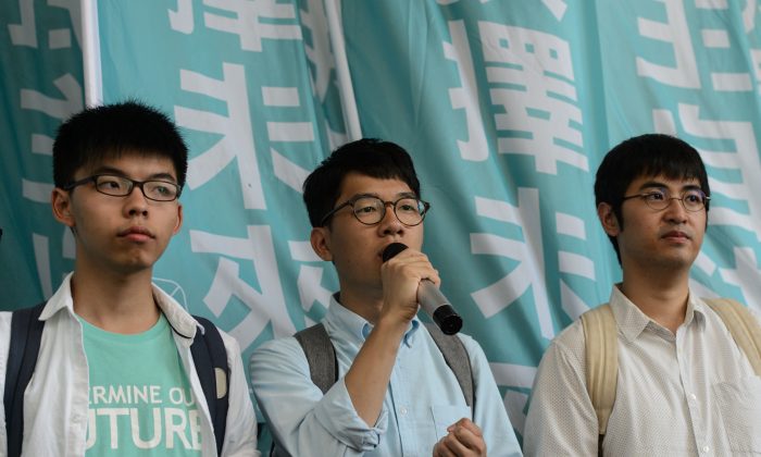 Pro-democracy political activists and members of the Demosisto party (L to R) Joshua Wong, Nathan Law and Alex Chow, speak as they arrive at the Eastern Court in Hong Kong on July 21, 2016.
The three were to face a court verdict over charges related to a protest leading up to pro-democracy rallies in 2014. (ANTHONY WALLACE/AFP/Getty Images)